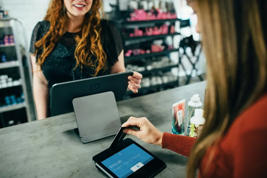 Une commerçante utilisant une tablette derrière son comptoir